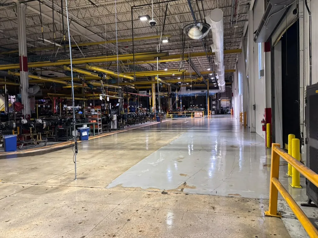 Completed concrete floor finish beside industrial machinery