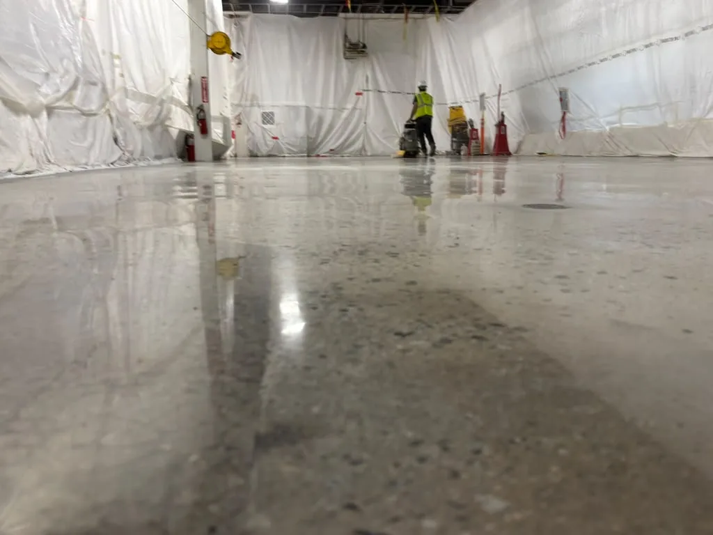 Reflective concrete finish in an interior work area protected by white sheeting